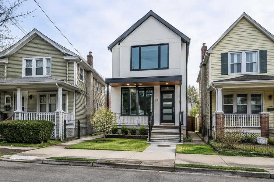 Modern new infill home between older houses with a small new front lawn in Garwood, NJ