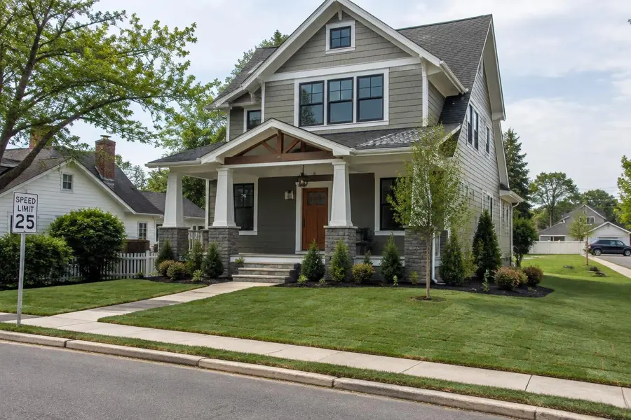 New craftsman-style home with freshly laid sod and young shrubs on a street in Fanwood, NJ