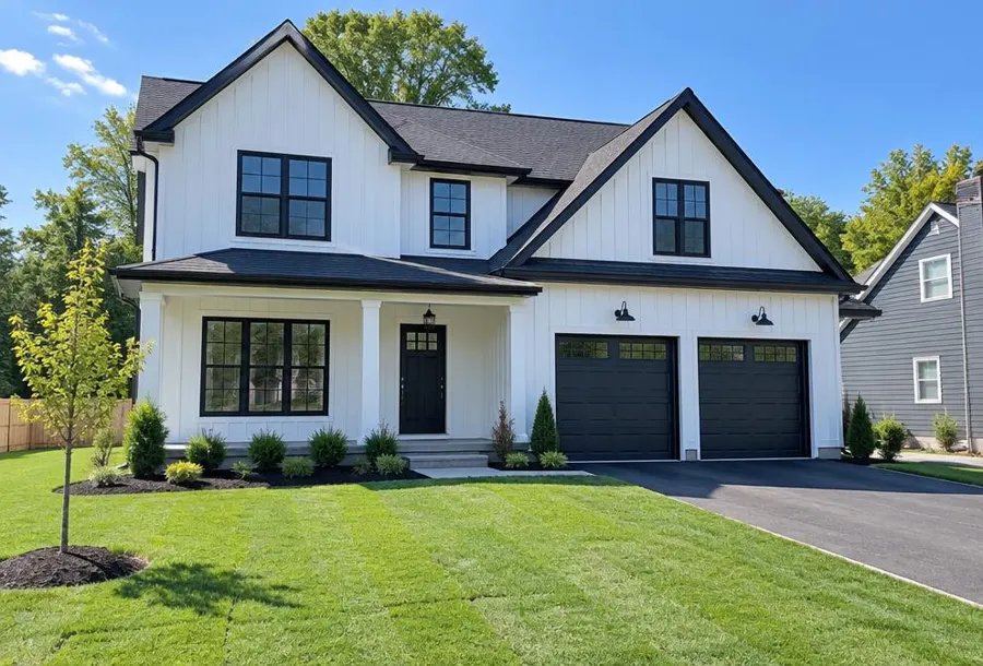 Newly built white farmhouse-style home with a freshly laid young sod lawn and new plantings in Millburn, NJ