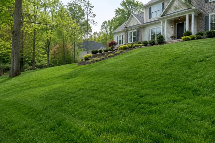 Green lawn on a sloping hillside rising to a home in Mountainside, NJ