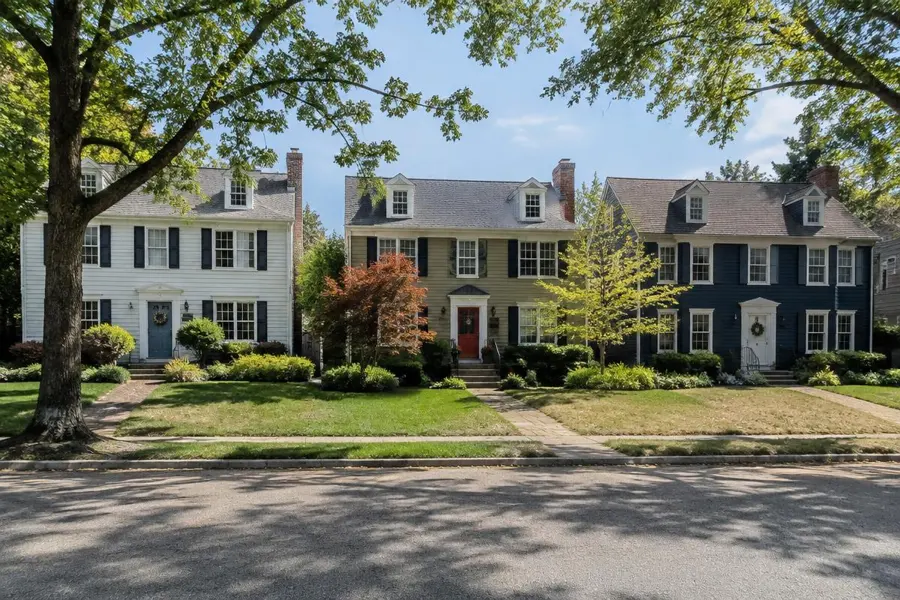 Three neighboring colonial homes with front lawns of different color and density in Fanwood, NJ