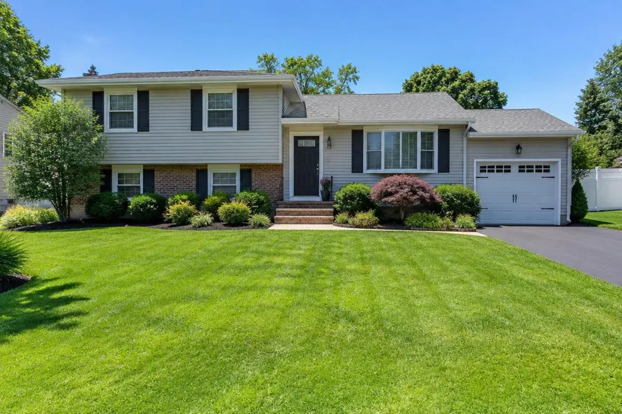 Healthy striped green lawn in full sun in front of a split-level home in Clark, NJ