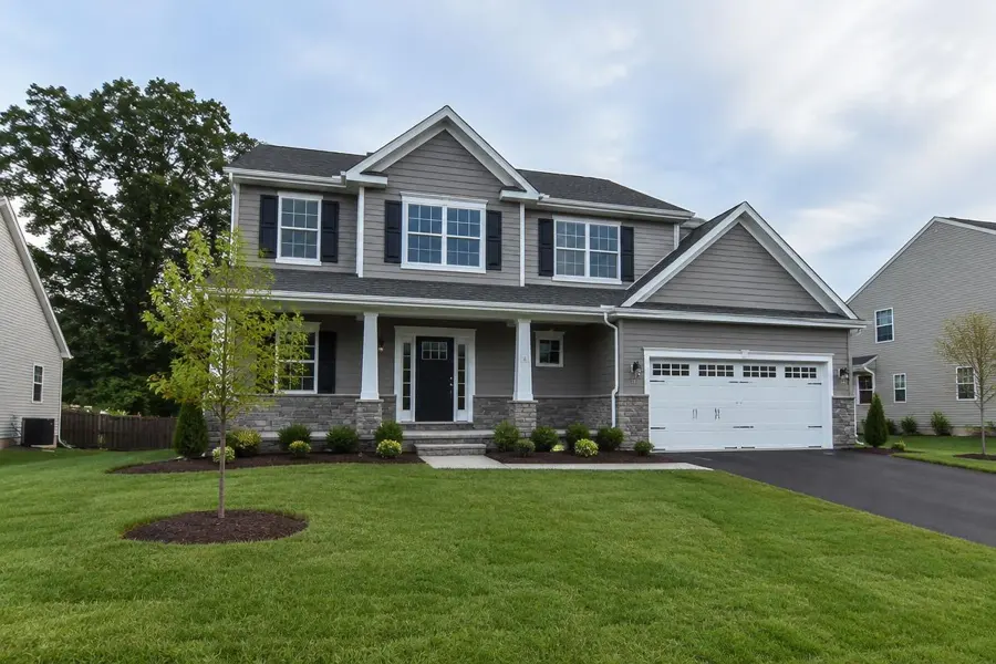 Newly rebuilt two-story home with a young lawn and fresh mulch beds in Clark, NJ