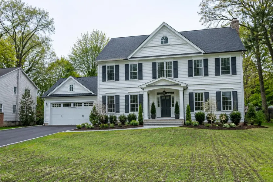 Newly built white colonial home with a freshly seeded young lawn and new plantings in Scotch Plains, NJ