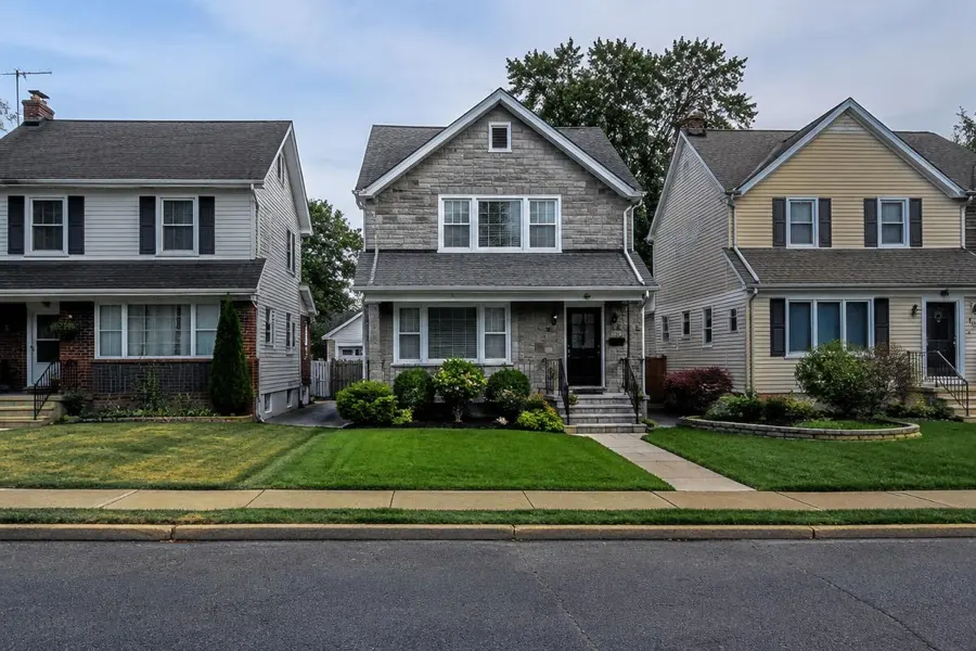 Row of neighboring homes whose front lawns vary in color and thickness in Union, NJ