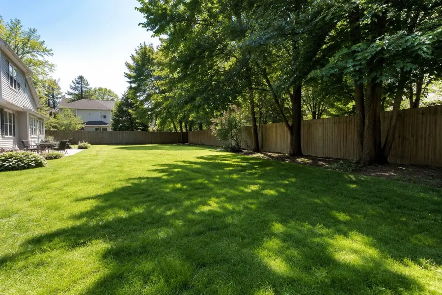 Fenced backyard lawn with an open sunny area and a shaded tree line in Fanwood, NJ